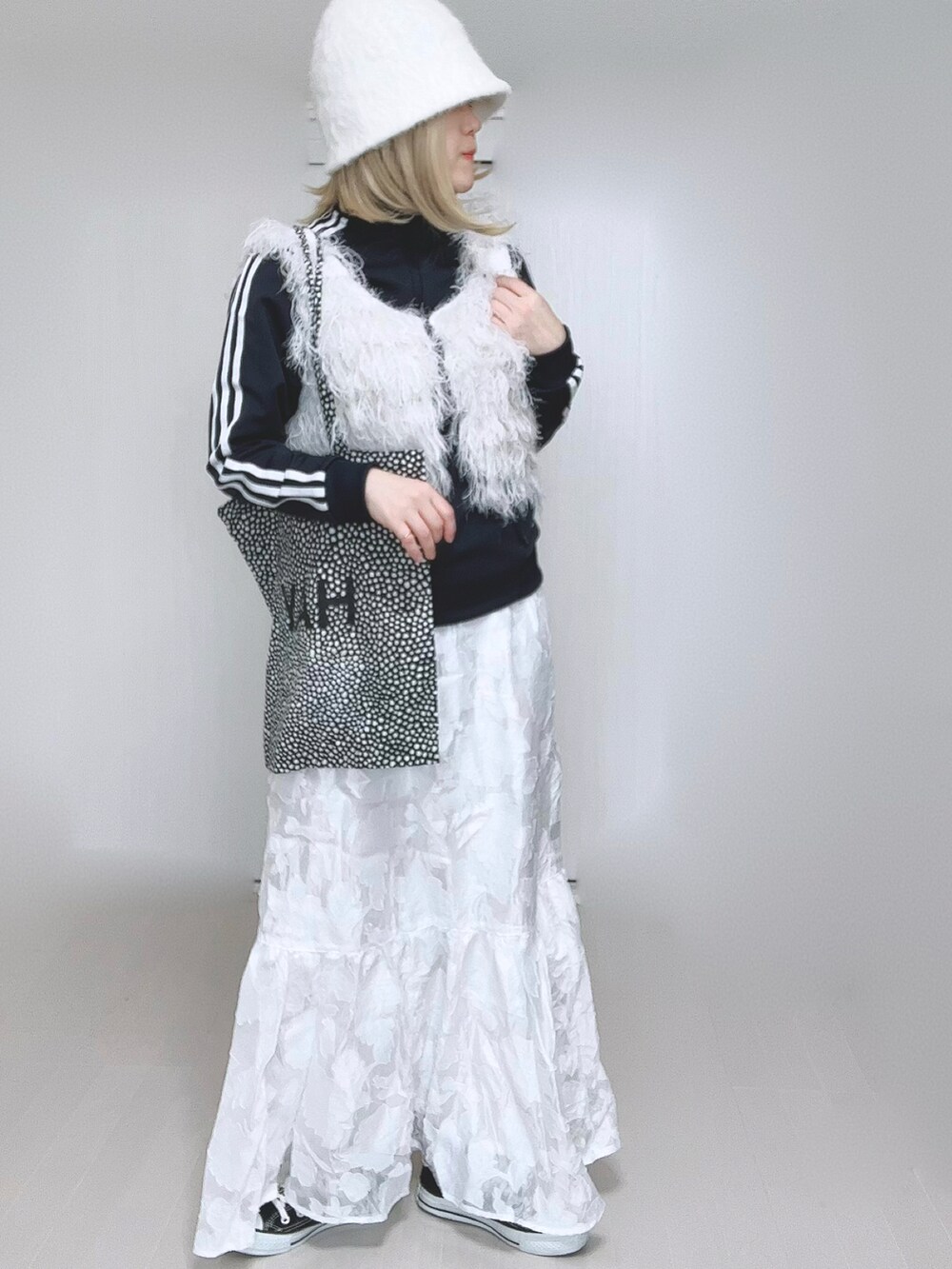 ホワイト系のベスト、ブルー系のナイロンジャケット、ホワイト系のスカートを着用したレディースの冬コーディネートの5枚目の写真