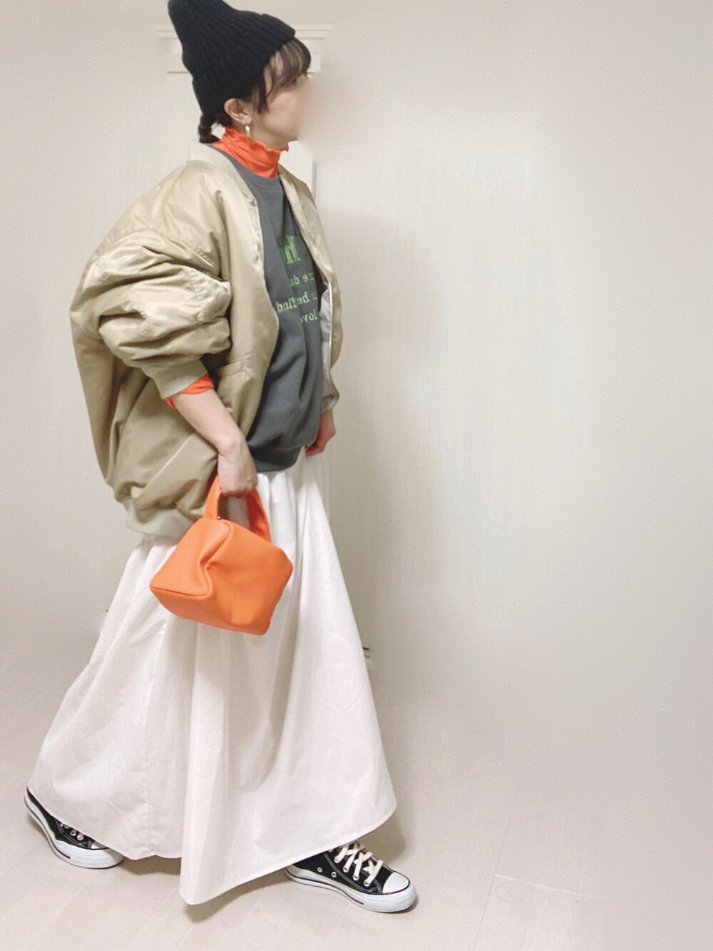 ベージュ系のMA-1、グレー系のスウェット、ホワイト系のスカートを着用したレディースの秋コーディネートの3枚目の写真