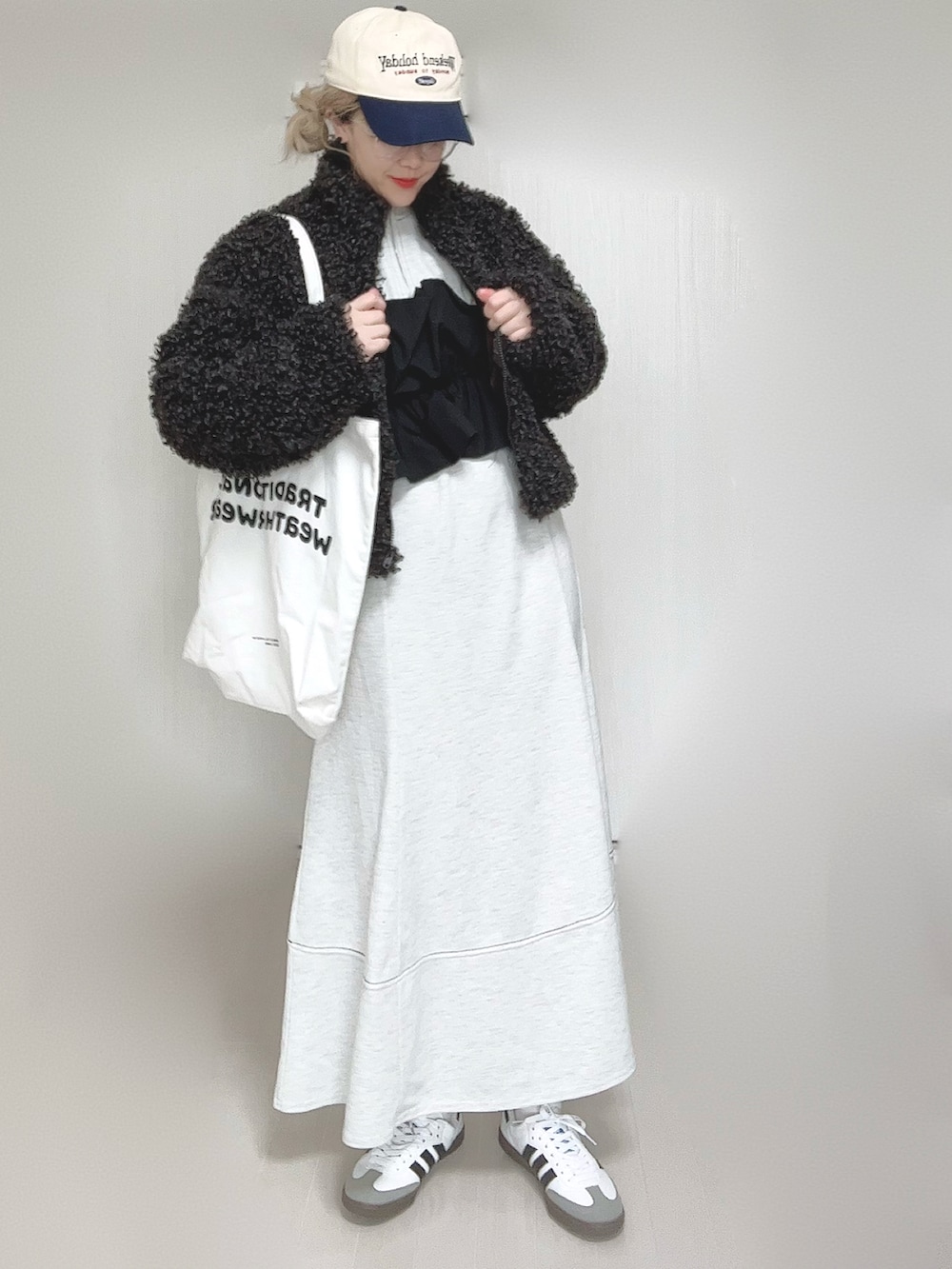 グレー系のブルゾン、グレー系のワンピース、ホワイト系のトートバッグを着用したレディースの秋コーディネートの2枚目の写真