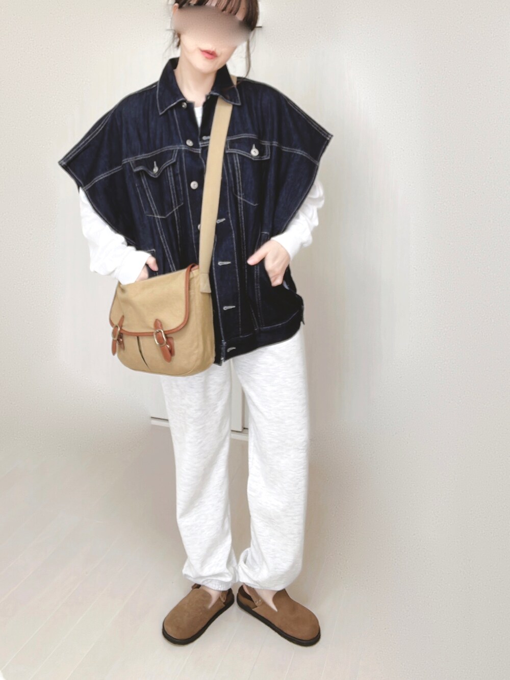 ブルー系のベスト、ホワイト系のTシャツ/カットソー、ベージュ系のショルダーバッグを着用したレディースの春コーディネートの4枚目の写真