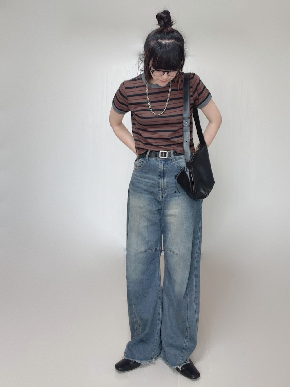 ブルー系のデニムパンツ、ブラウン系のTシャツ/カットソー、ブラック系のスリッポンを着用したレディースの秋コーディネートの3枚目の写真