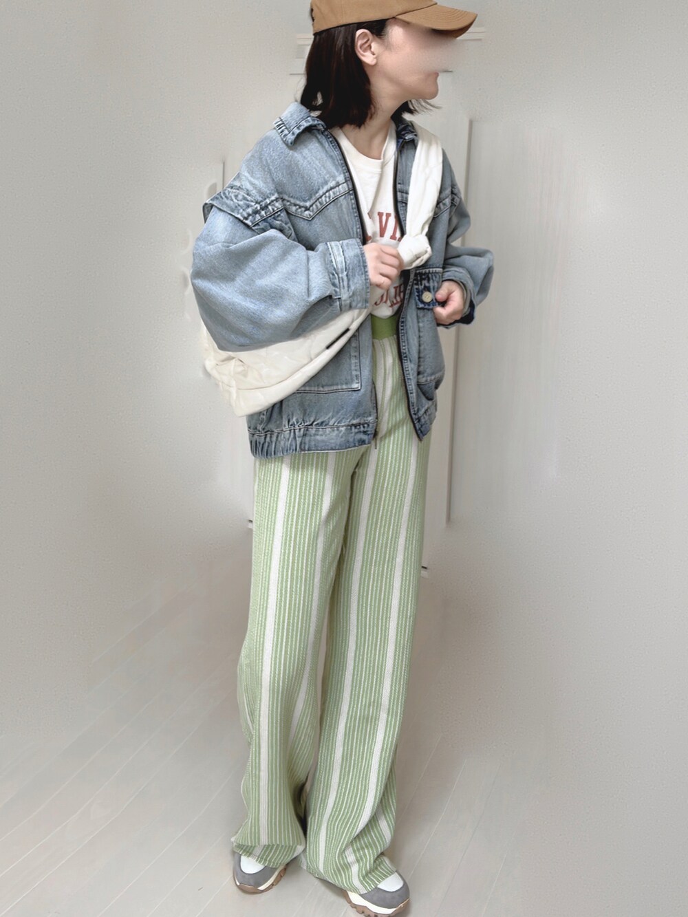 ブルー系のブルゾン、ホワイト系のショルダーバッグ、グリーン系のその他パンツを着用したレディースの春コーディネートの3枚目の写真