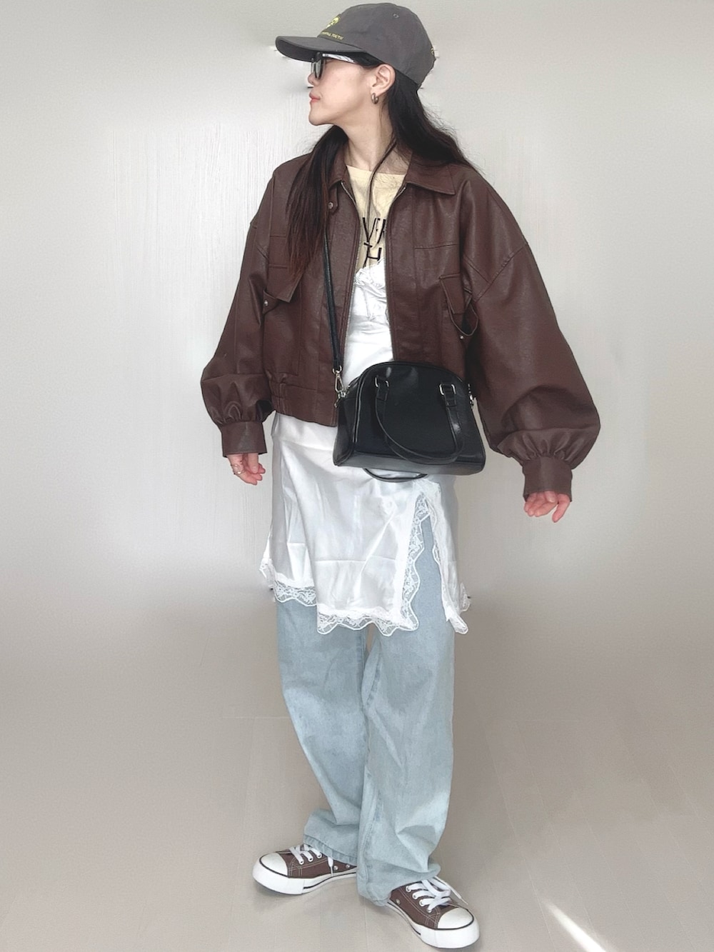 ベージュ系のTシャツ/カットソー、ブラウン系のブルゾン、ホワイト系のワンピースを着用したレディースの冬コーディネートの2枚目の写真