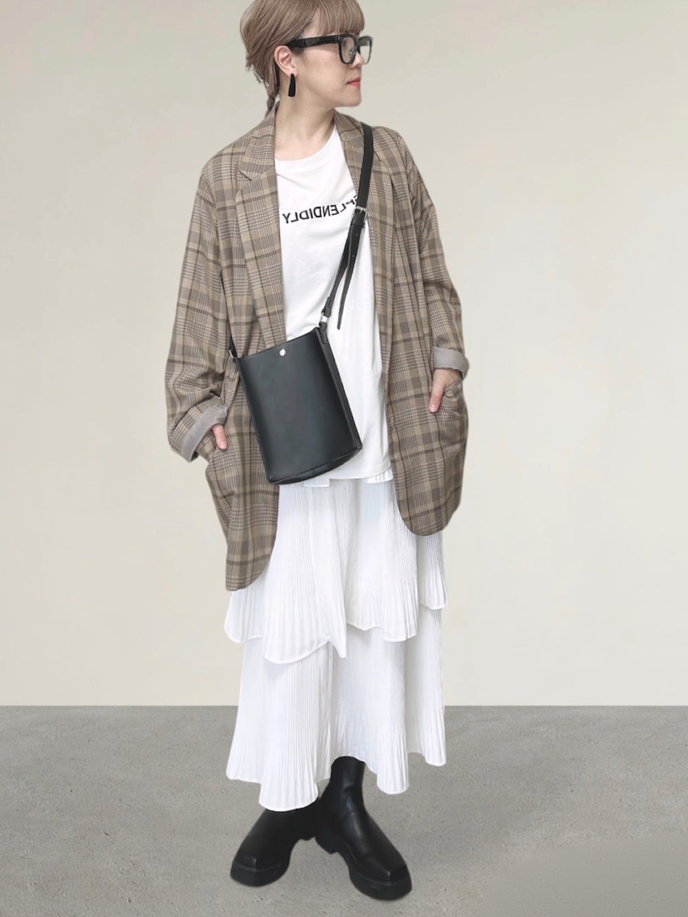 ホワイト系のスカート、ベージュ系のテーラードジャケット、ブラック系のショルダーバッグを着用したレディースの秋コーディネートの2枚目の写真