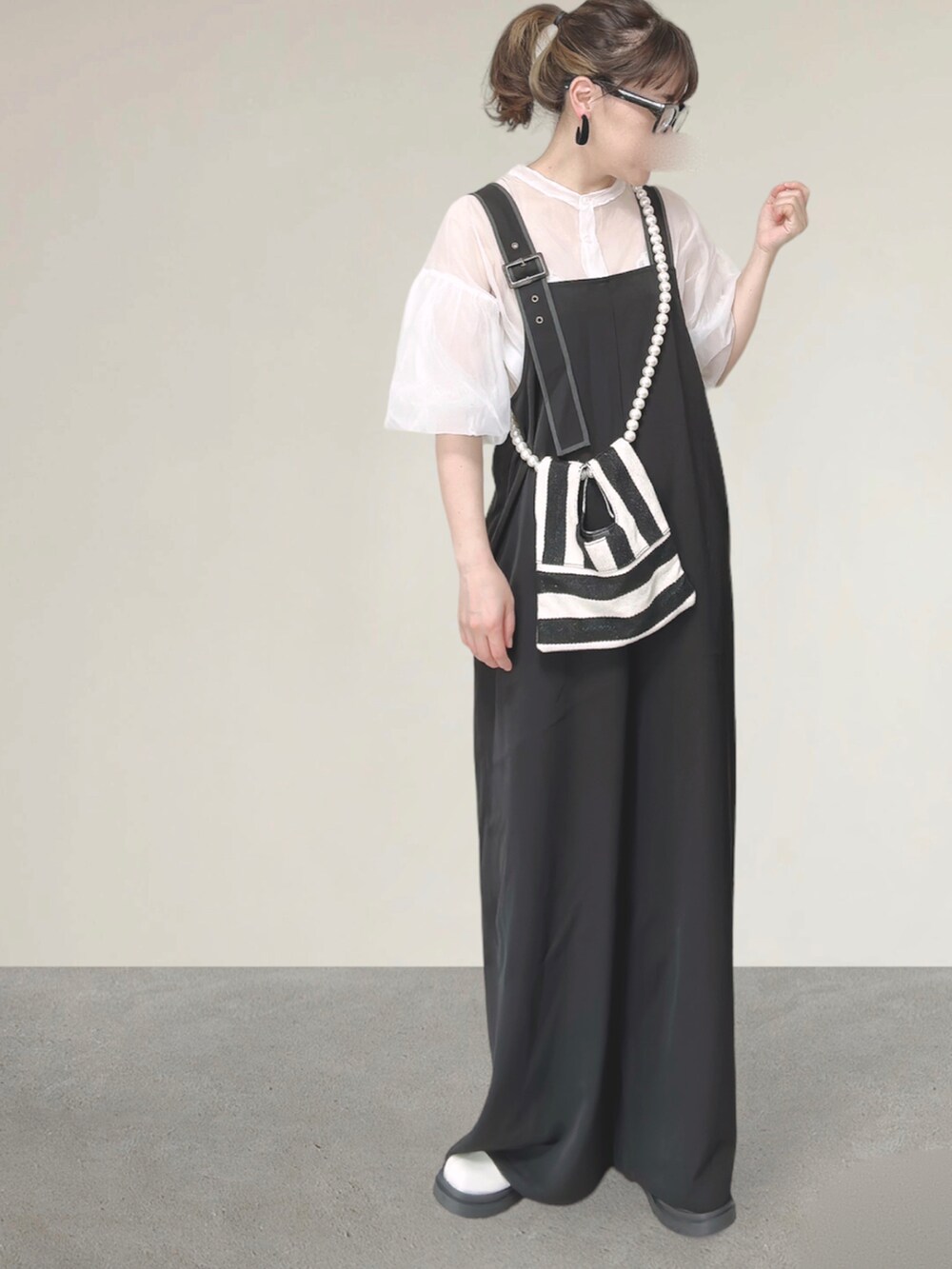 ブラック系のサロペット/オーバーオール、ホワイト系のシャツ/ブラウス、ホワイト系のショルダーバッグを着用したレディースの秋コーディネートの4枚目の写真