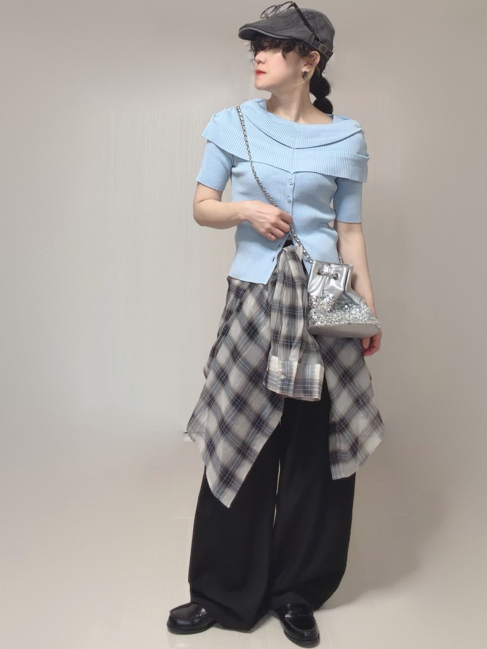 ブルー系のニット/セーター、ホワイト系のシャツ/ブラウス、ブラック系のスラックスを着用したレディースの春コーディネートの3枚目の写真