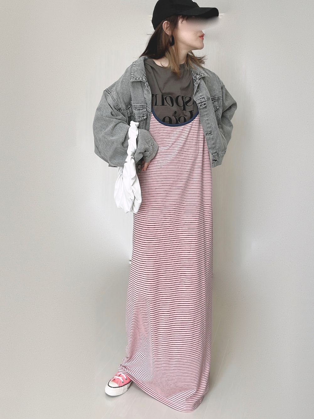 ピンク系のワンピース、ブラック系のデニムジャケット、ピンク系のスニーカーを着用したレディースの秋コーディネートの2枚目の写真