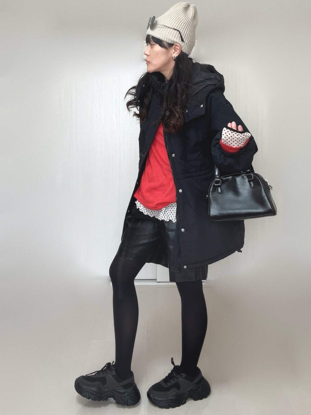 ホワイト系のTシャツ/カットソー、ブラック系のダウンジャケット/コート、レッド系のTシャツ/カットソーを着用したレディースの冬コーディネートの3枚目の写真