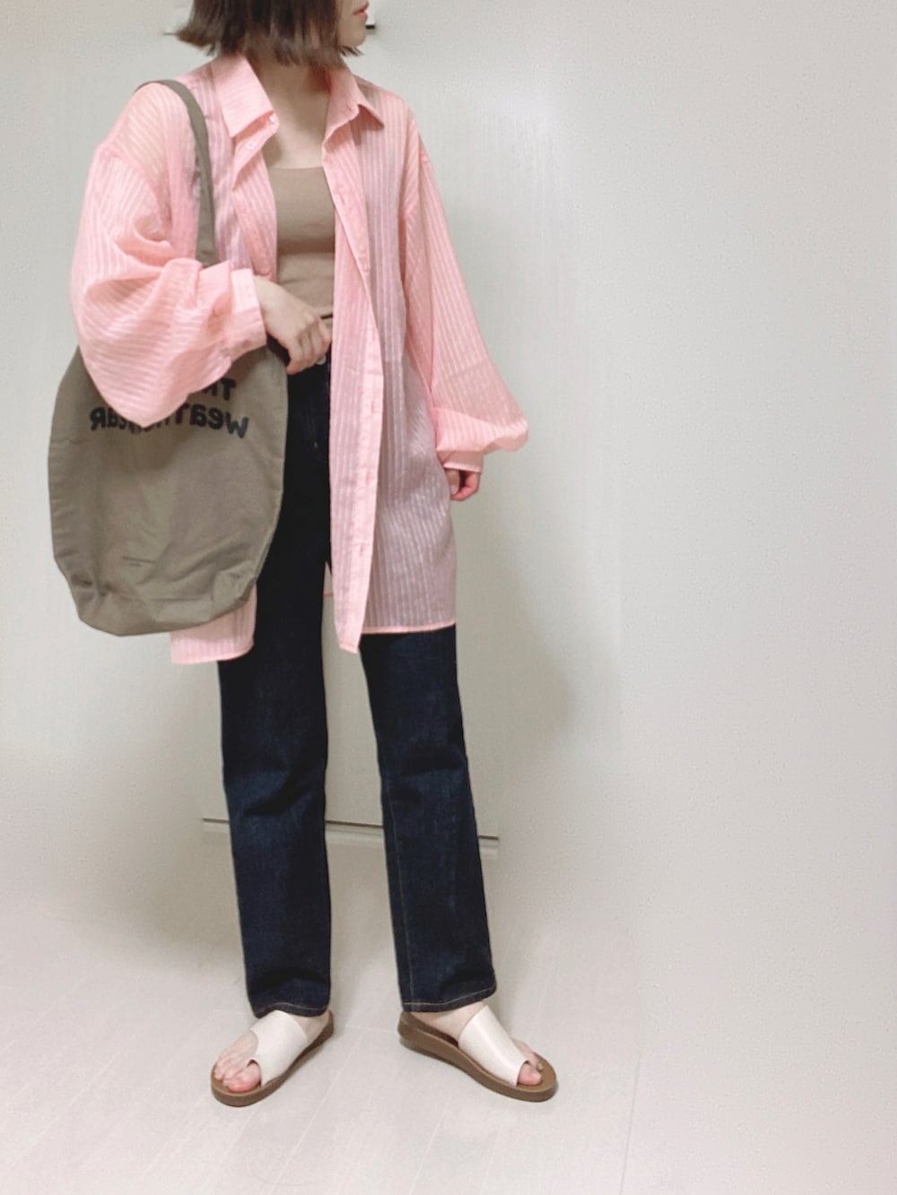 ピンク系のシャツ/ブラウス、ブラウン系のトートバッグ、ブルー系のデニムパンツを着用したレディースの夏コーディネートの5枚目の写真