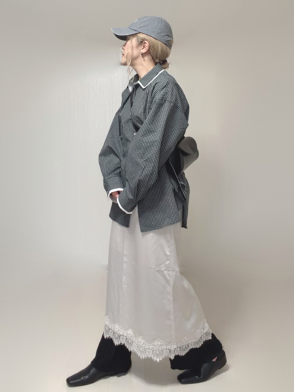 ブラック系のスリッポン、ホワイト系のスカート、ブラック系のその他パンツを着用したレディースの夏コーディネートの3枚目の写真