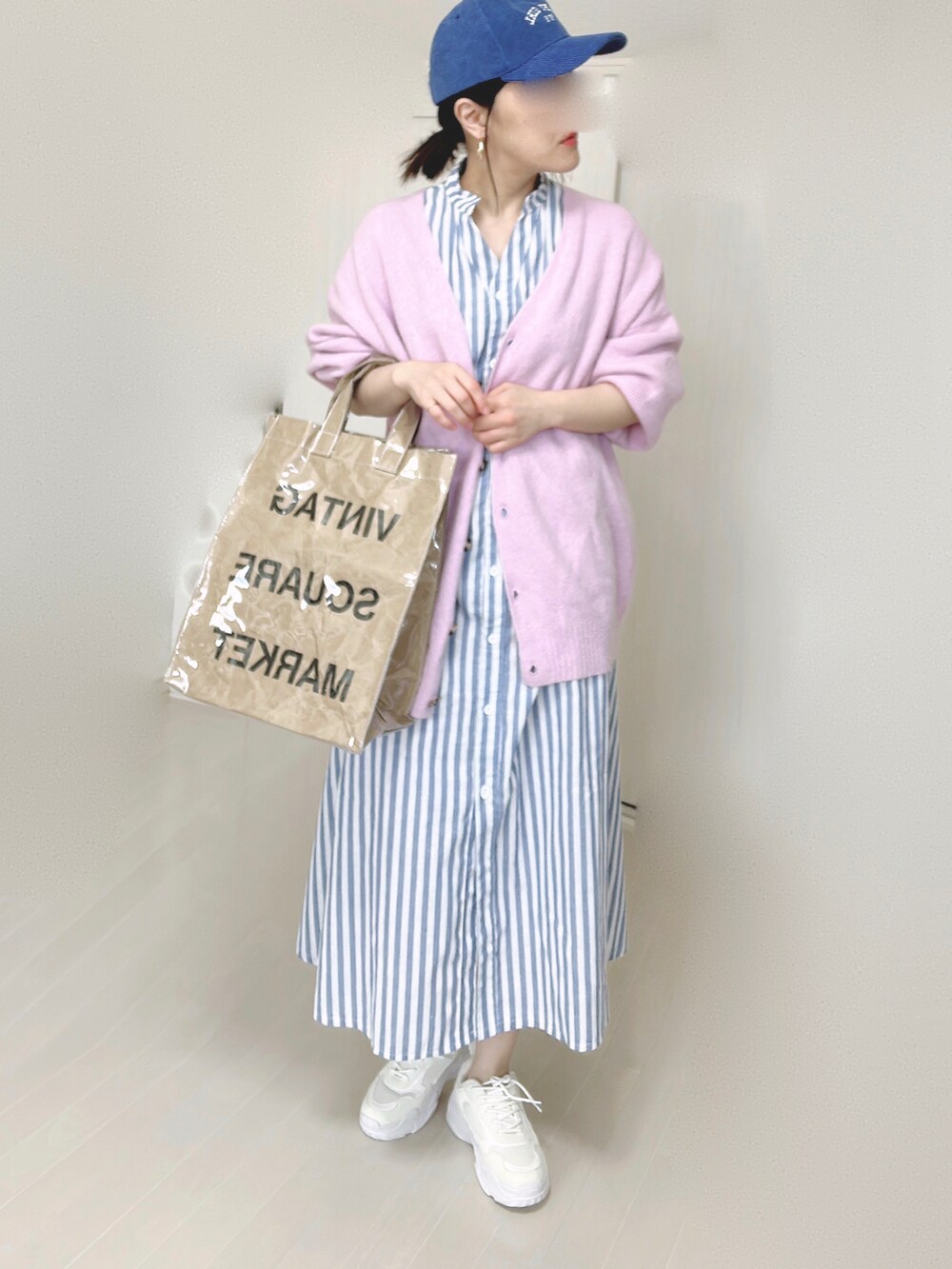 ブルー系のシャツワンピース、パープル系のカーディガン/ボレロ、グリーン系のトートバッグを着用したレディースの春コーディネートの4枚目の写真