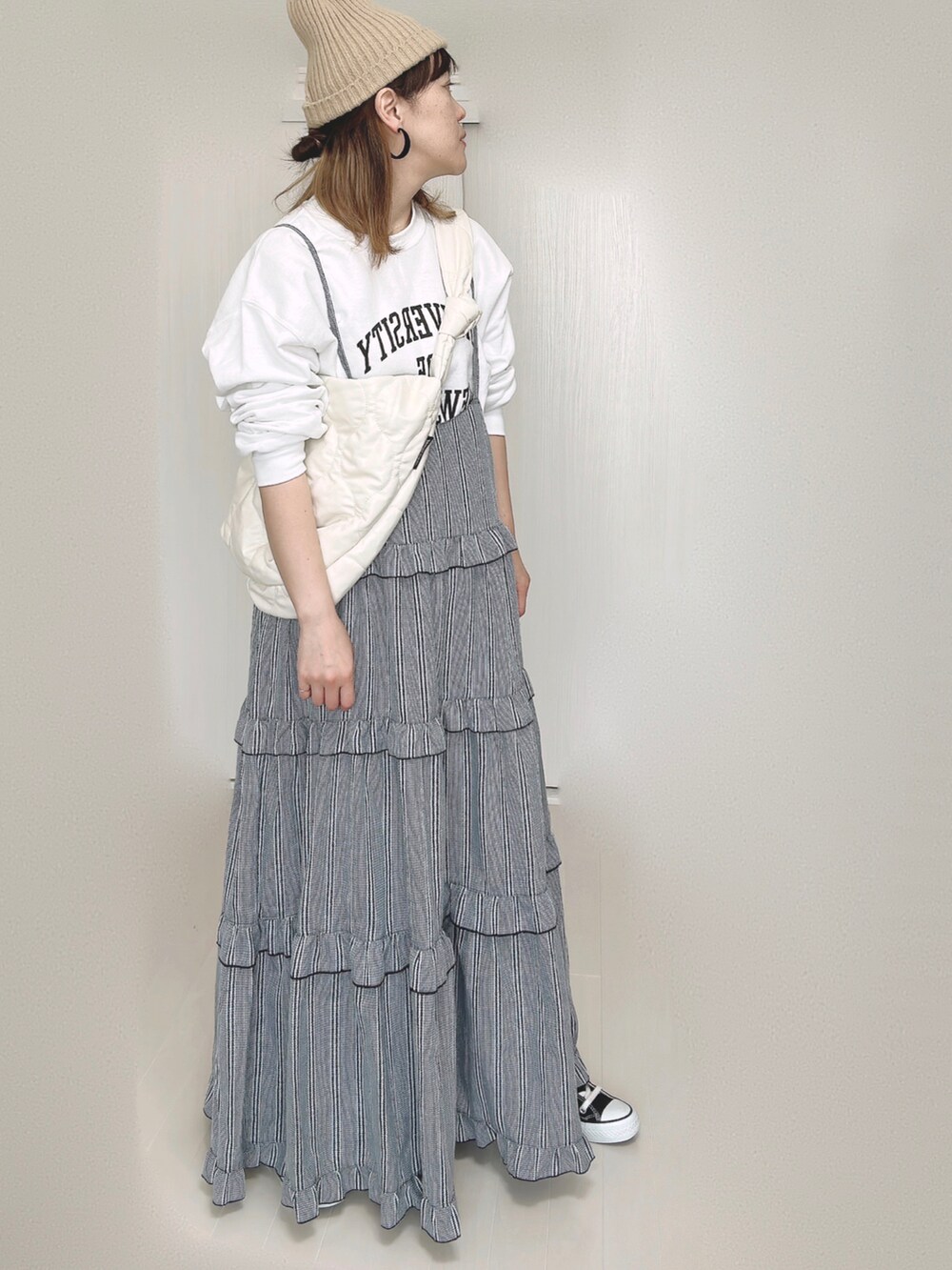 ホワイト系のスウェット、ホワイト系のショルダーバッグ、ブラック系のワンピースを着用したレディースの秋コーディネートの4枚目の写真