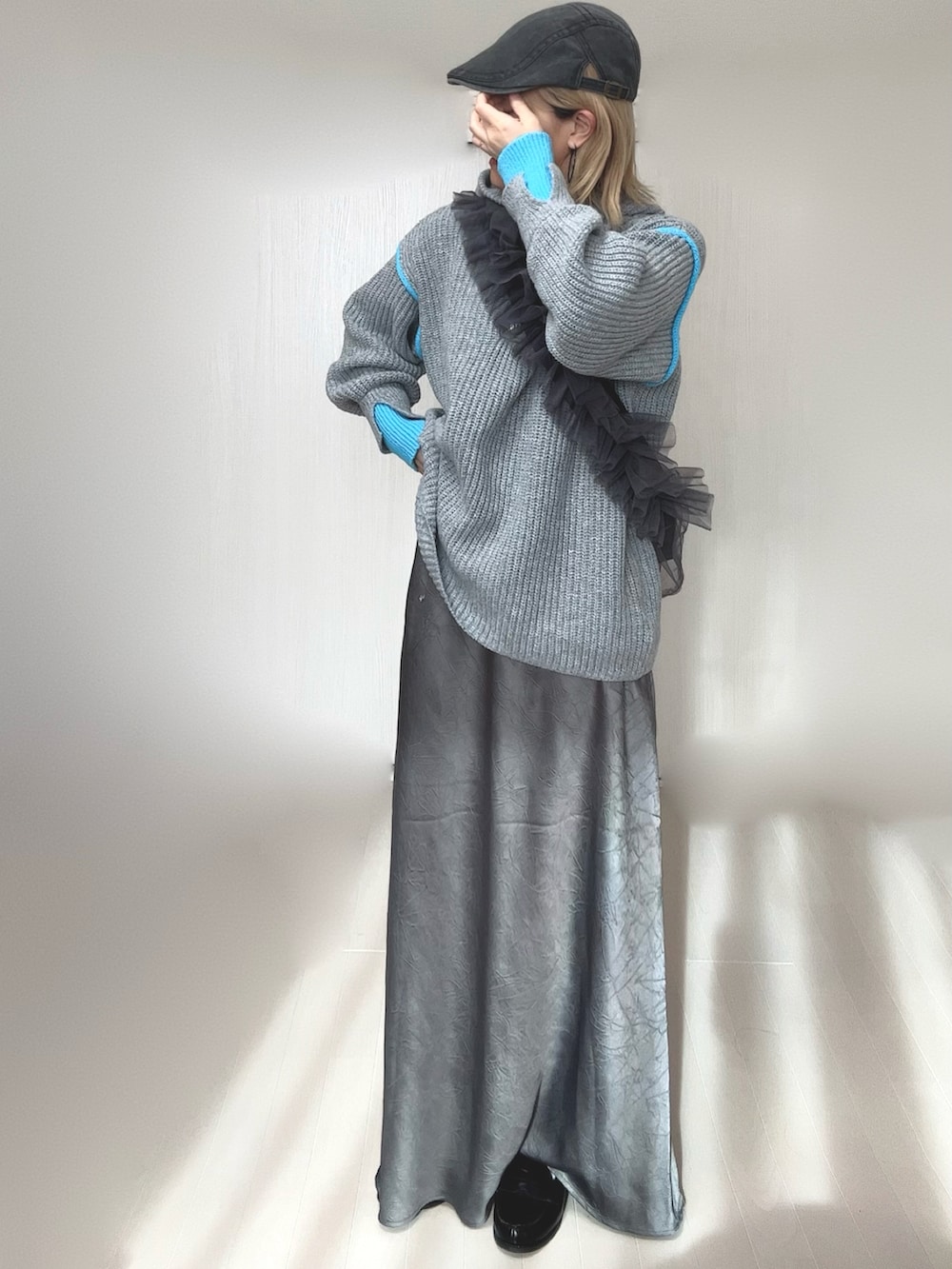 グレー系のニット/セーター、グレー系のスカート、グレー系のショルダーバッグを着用したレディースの冬コーディネートの5枚目の写真