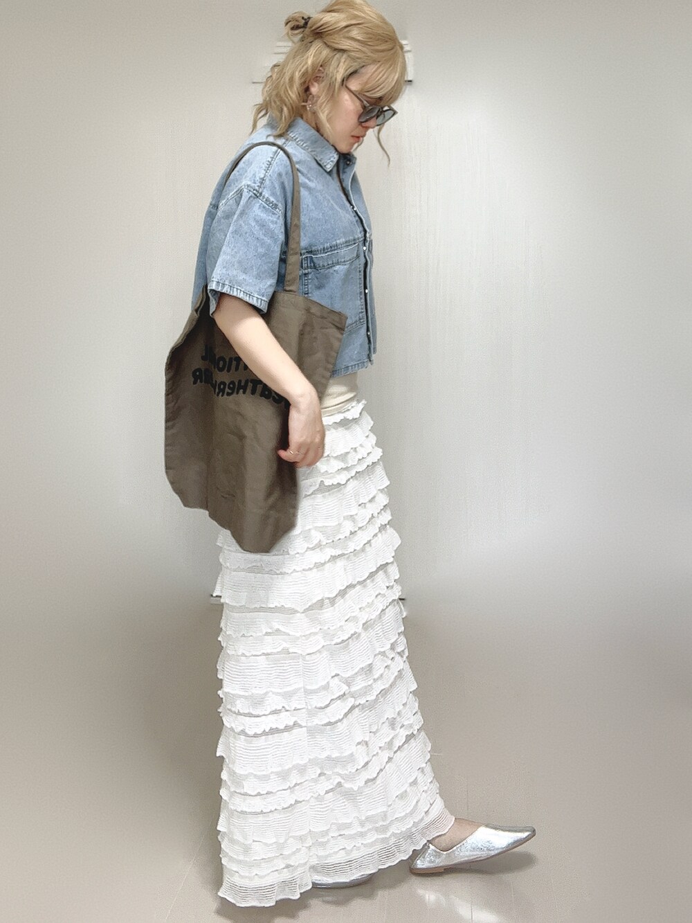 ブルー系のシャツ/ブラウス、ブラウン系のトートバッグ、ホワイト系のスカートを着用したレディースの夏コーディネートの5枚目の写真