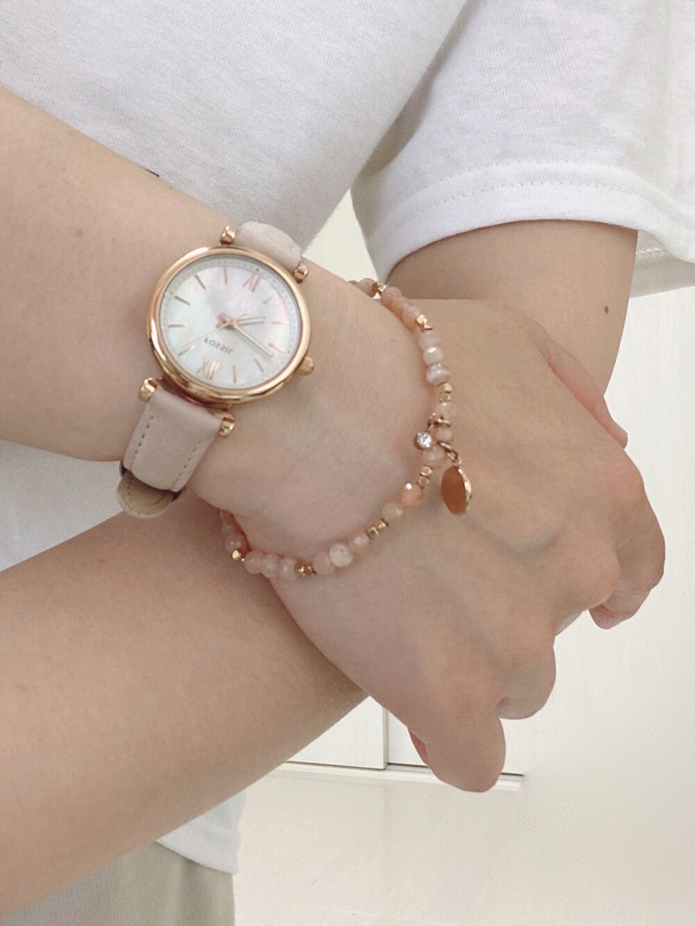 ホワイト系のTシャツ/カットソー、ブラック系のショルダーバッグ、ベージュ系のアナログ腕時計を着用したレディースの夏コーディネートの3枚目の写真