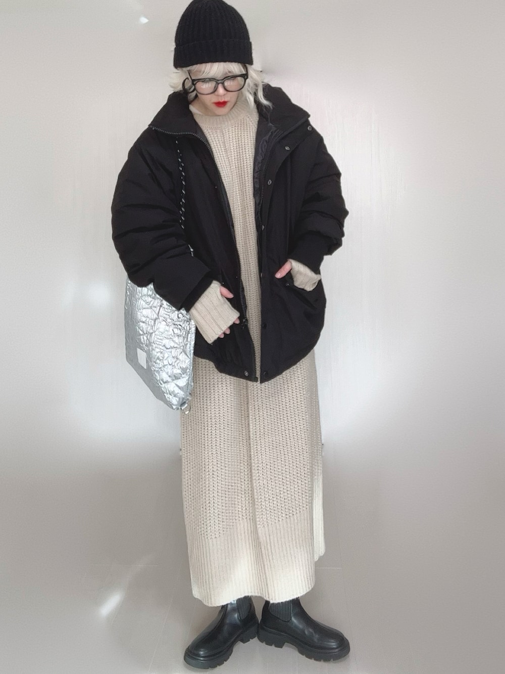 ブラック系のブルゾン、ホワイト系のワンピース、シルバー系のトートバッグを着用したレディースの冬コーディネートの4枚目の写真