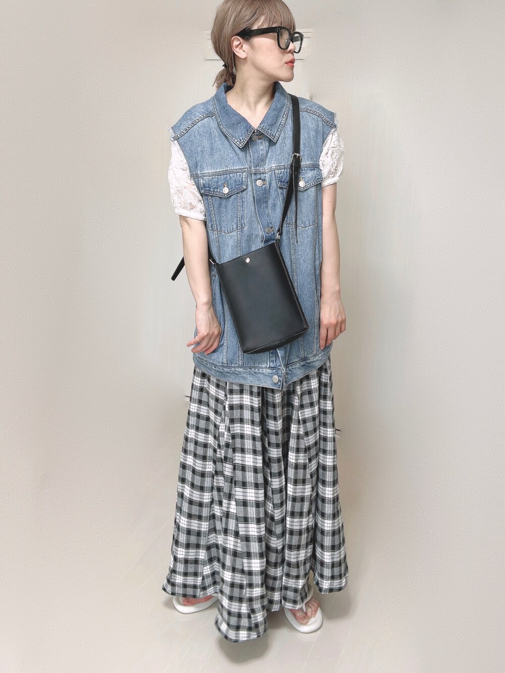 ブルー系のベスト、ホワイト系のシャツ/ブラウス、ブラック系のショルダーバッグを着用したレディースの夏コーディネートの2枚目の写真