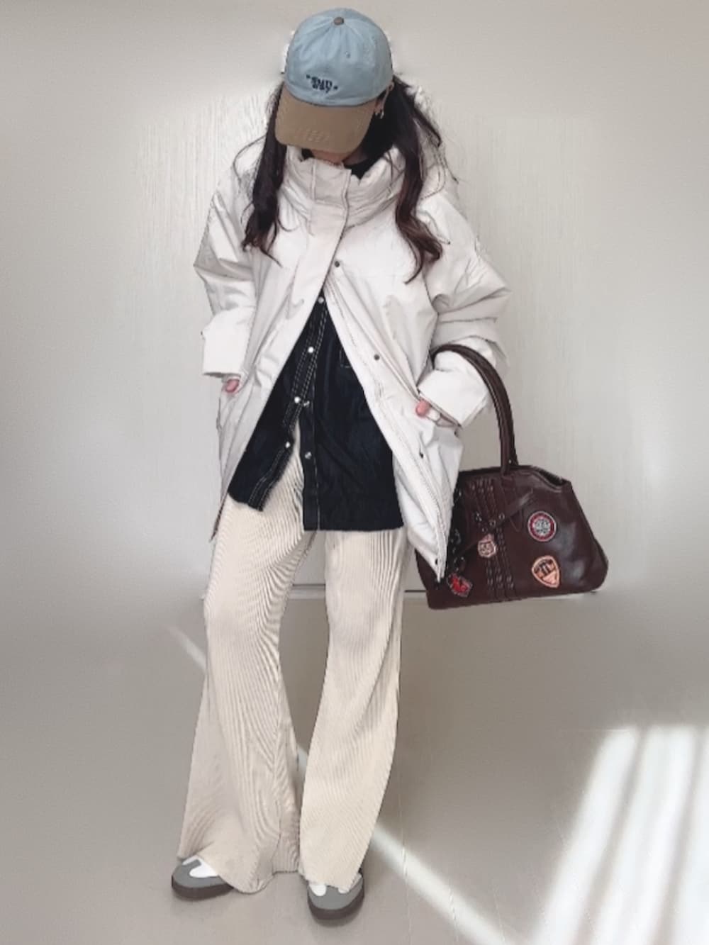 ホワイト系のブルゾン、ブラック系のシャツ/ブラウス、ホワイト系のその他パンツを着用したレディースの冬コーディネートの3枚目の写真