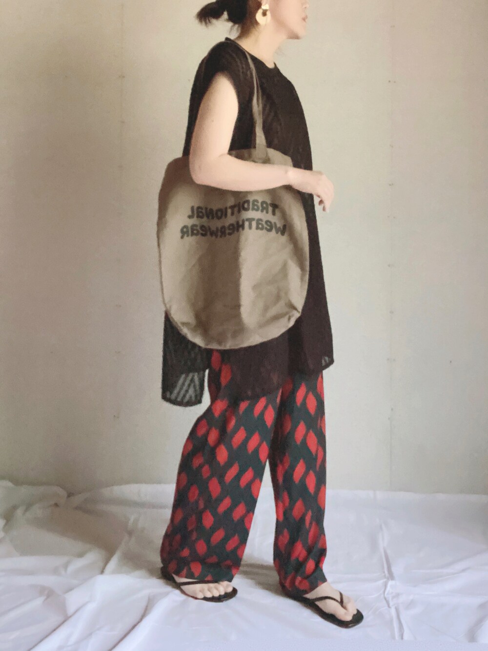 グリーン系のその他パンツ、ブラック系のベスト、ブラウン系のトートバッグを着用したレディースの夏コーディネートの4枚目の写真