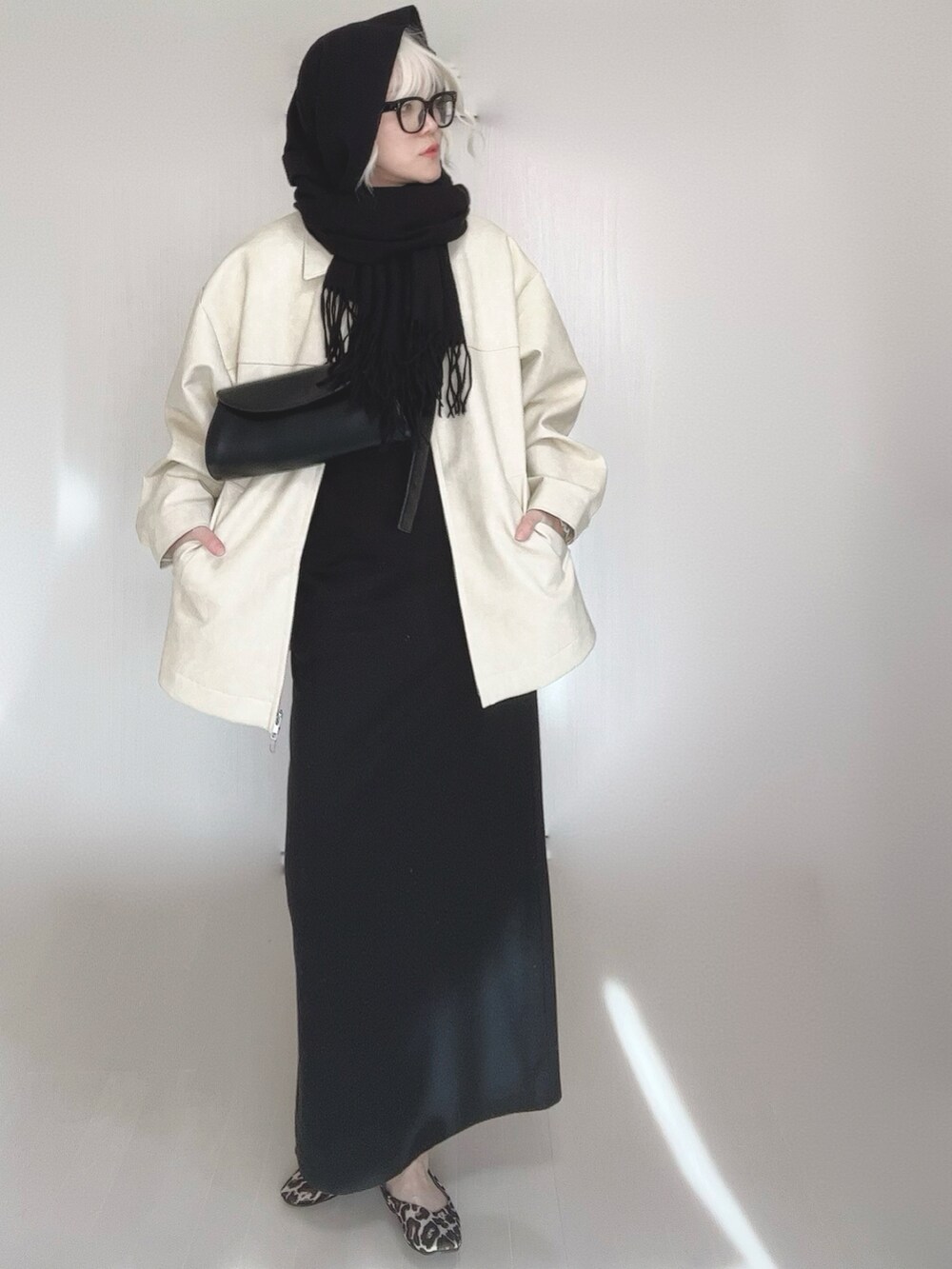 ホワイト系のブルゾン、ブラック系のワンピース、その他のバレエシューズを着用したレディースの冬コーディネートの2枚目の写真