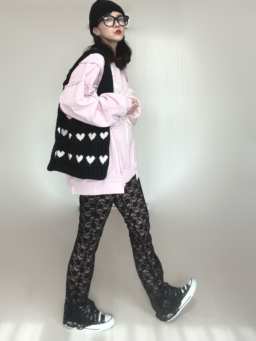 ピンク系のスウェット、ブラック系のその他パンツ、ブラック系のスニーカーを着用したレディースの冬コーディネートの3枚目の写真