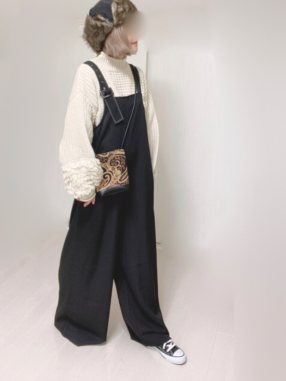ホワイト系のニット/セーター、ブラック系のサロペット/オーバーオール、ブラック系のショルダーバッグを着用したレディースの秋コーディネートの4枚目の写真