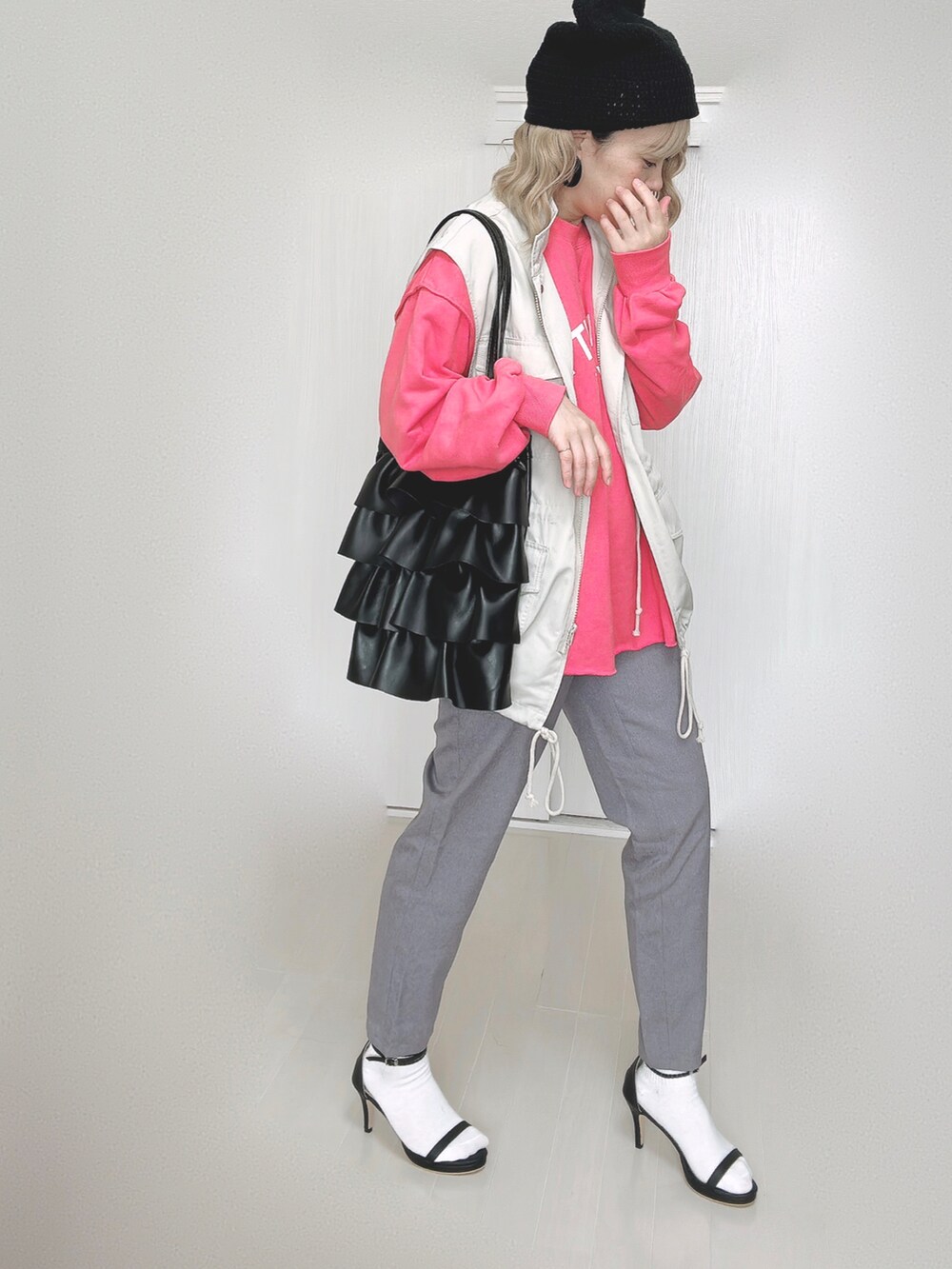 グレー系のその他パンツ、ピンク系のスウェット、ホワイト系のベストを着用したレディースの秋コーディネートの2枚目の写真