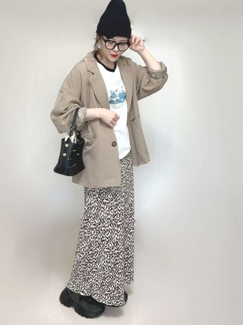 ホワイト系のTシャツ/カットソー、ベージュ系のセットアップ、ブラック系のショルダーバッグを着用したレディースの春コーディネートの5枚目の写真