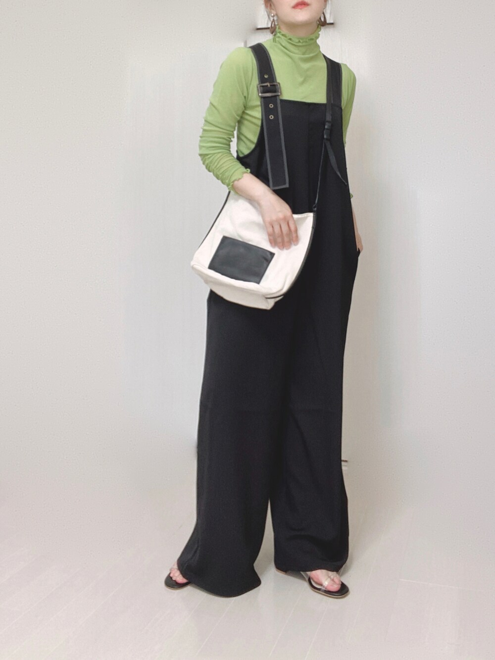 ブラック系のサロペット/オーバーオール、グリーン系のTシャツ/カットソー、ホワイト系のショルダーバッグを着用したレディースの夏コーディネートの2枚目の写真