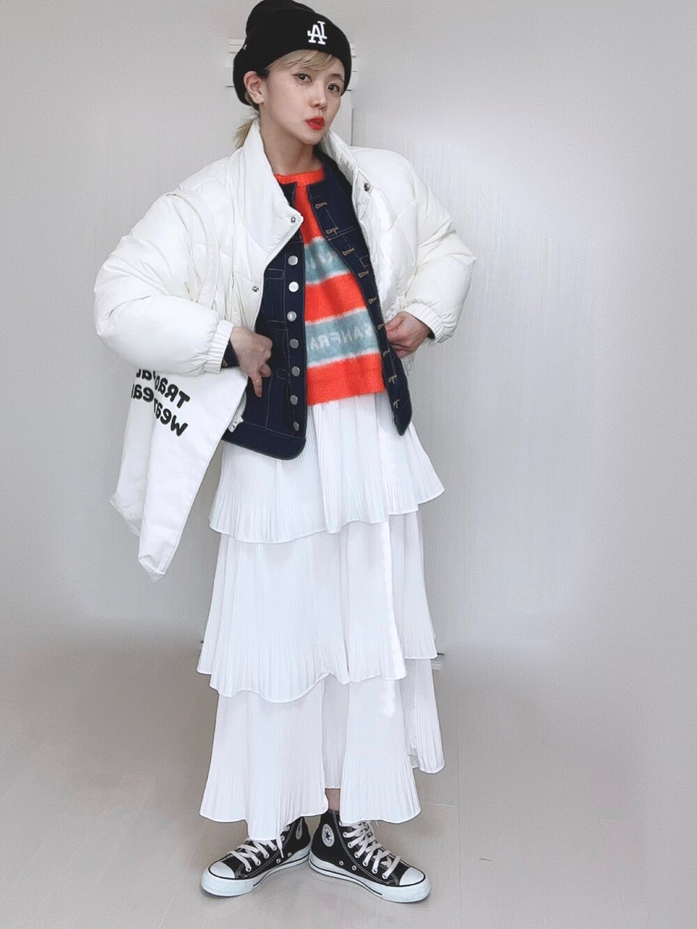 ホワイト系のダウンジャケット/コート、ブルー系のデニムジャケット、オレンジ系のニット/セーターを着用したレディースの冬コーディネートの2枚目の写真