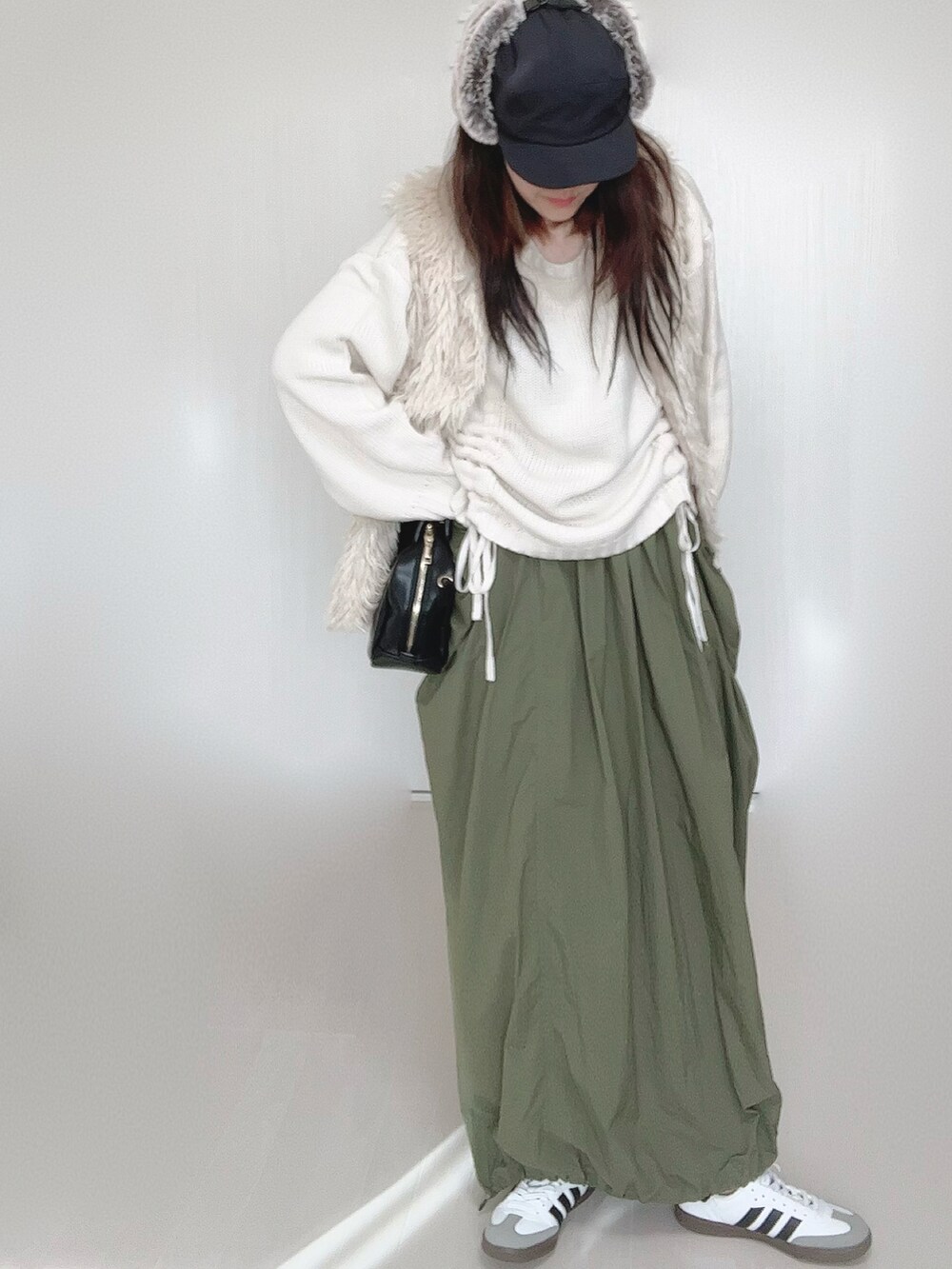 ホワイト系のニット/セーター、ホワイト系のベスト、ブラック系のボストンバッグを着用したレディースの秋コーディネートの4枚目の写真