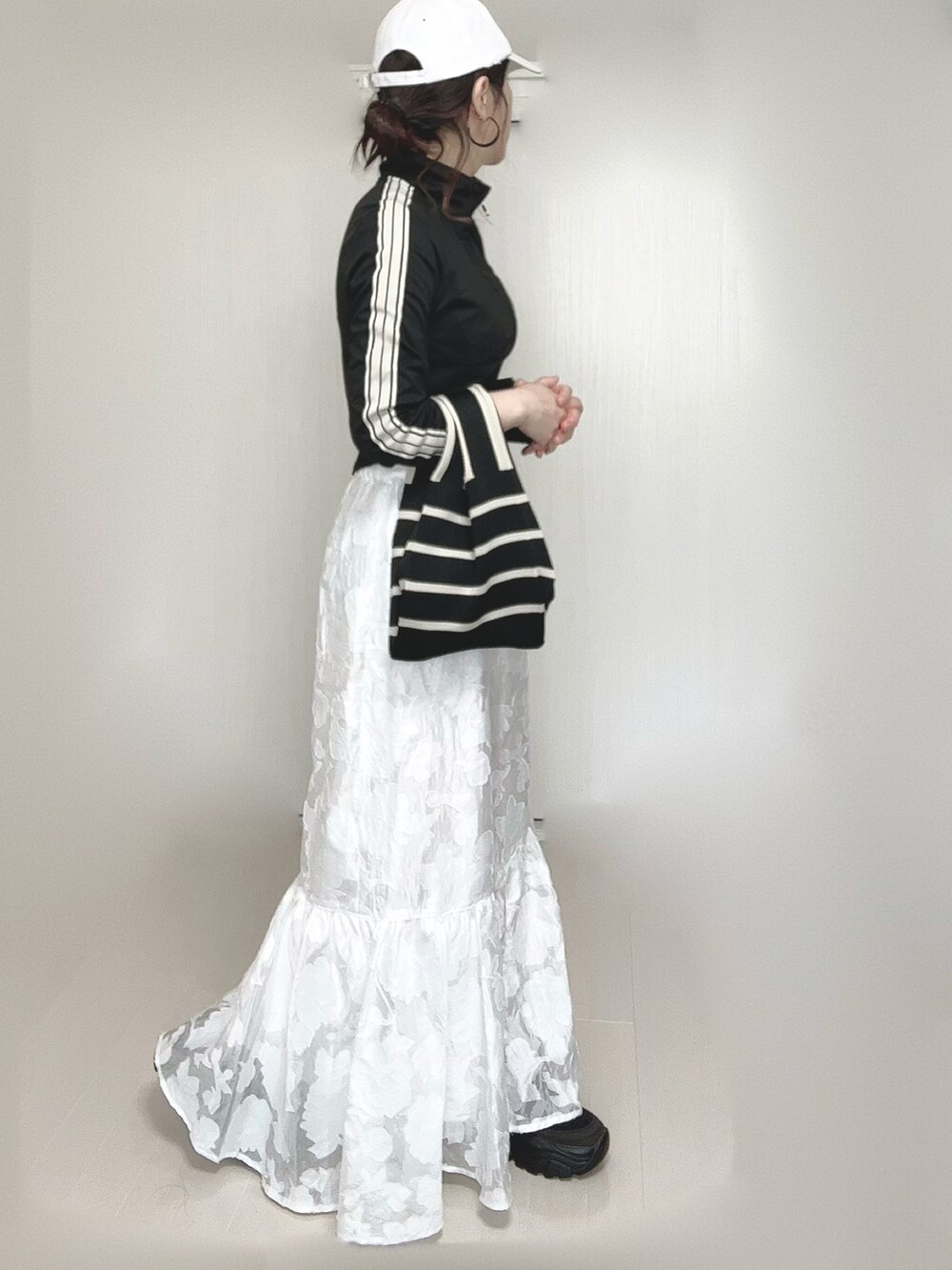 ブラック系のジャージ、その他のトートバッグ、ホワイト系のスカートを着用したレディースの春コーディネートの5枚目の写真