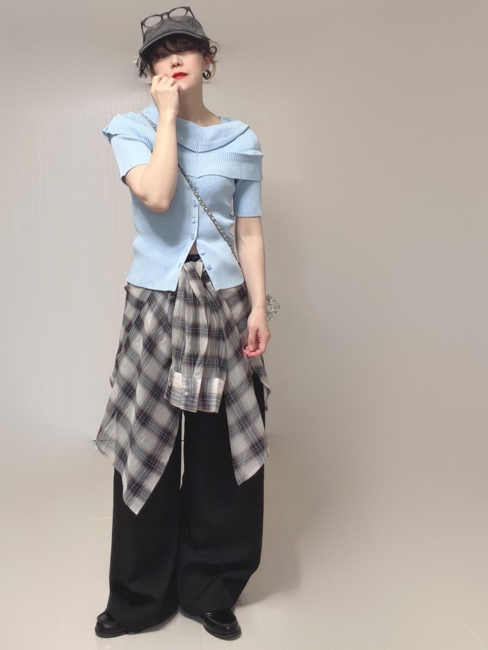 ブルー系のニット/セーター、ホワイト系のシャツ/ブラウス、ブラック系のスラックスを着用したレディースの春コーディネートの2枚目の写真