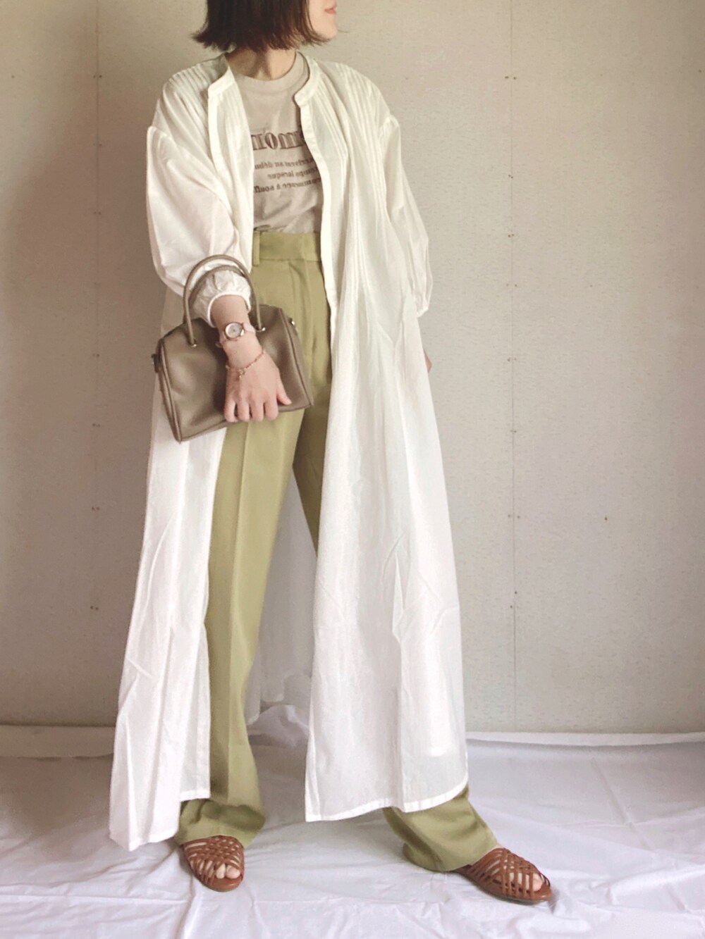 グリーン系のスラックス、ホワイト系のシャツワンピース、ブラウン系のサンダルを着用したレディースの夏コーディネートの5枚目の写真