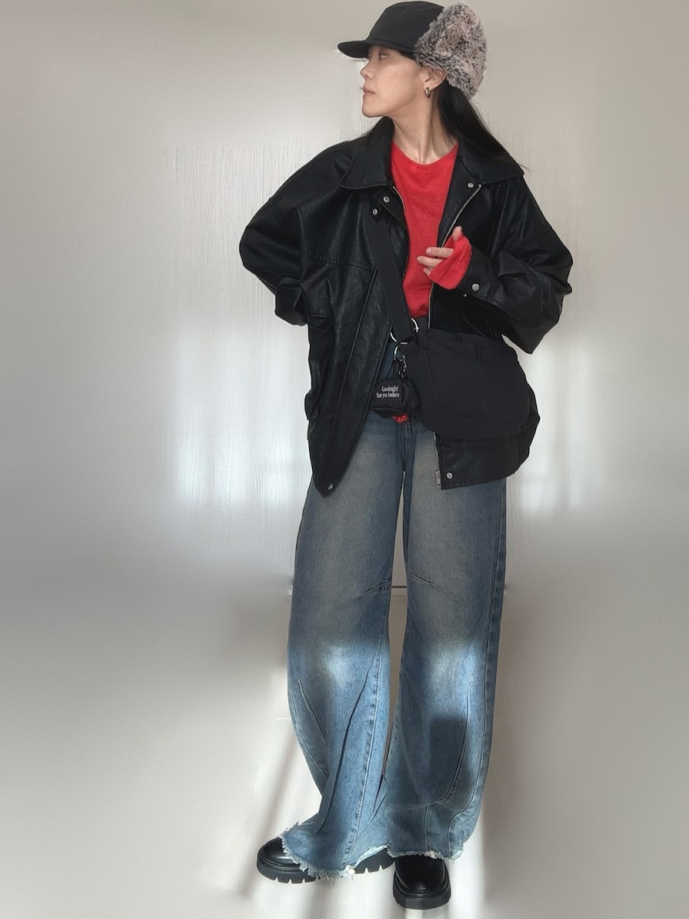 ブラック系のブルゾン、レッド系のTシャツ/カットソー、ブラック系のブーツを着用したレディースの冬コーディネートの4枚目の写真