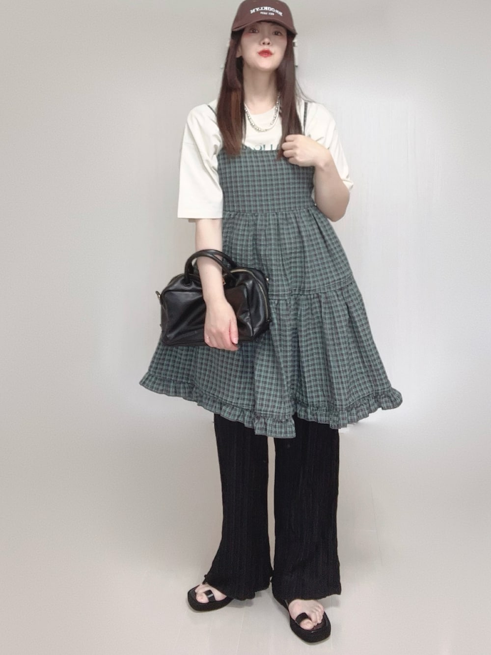 グレー系のワンピース、ホワイト系のTシャツ/カットソー、ブラック系のボストンバッグを着用したレディースの夏コーディネートの3枚目の写真