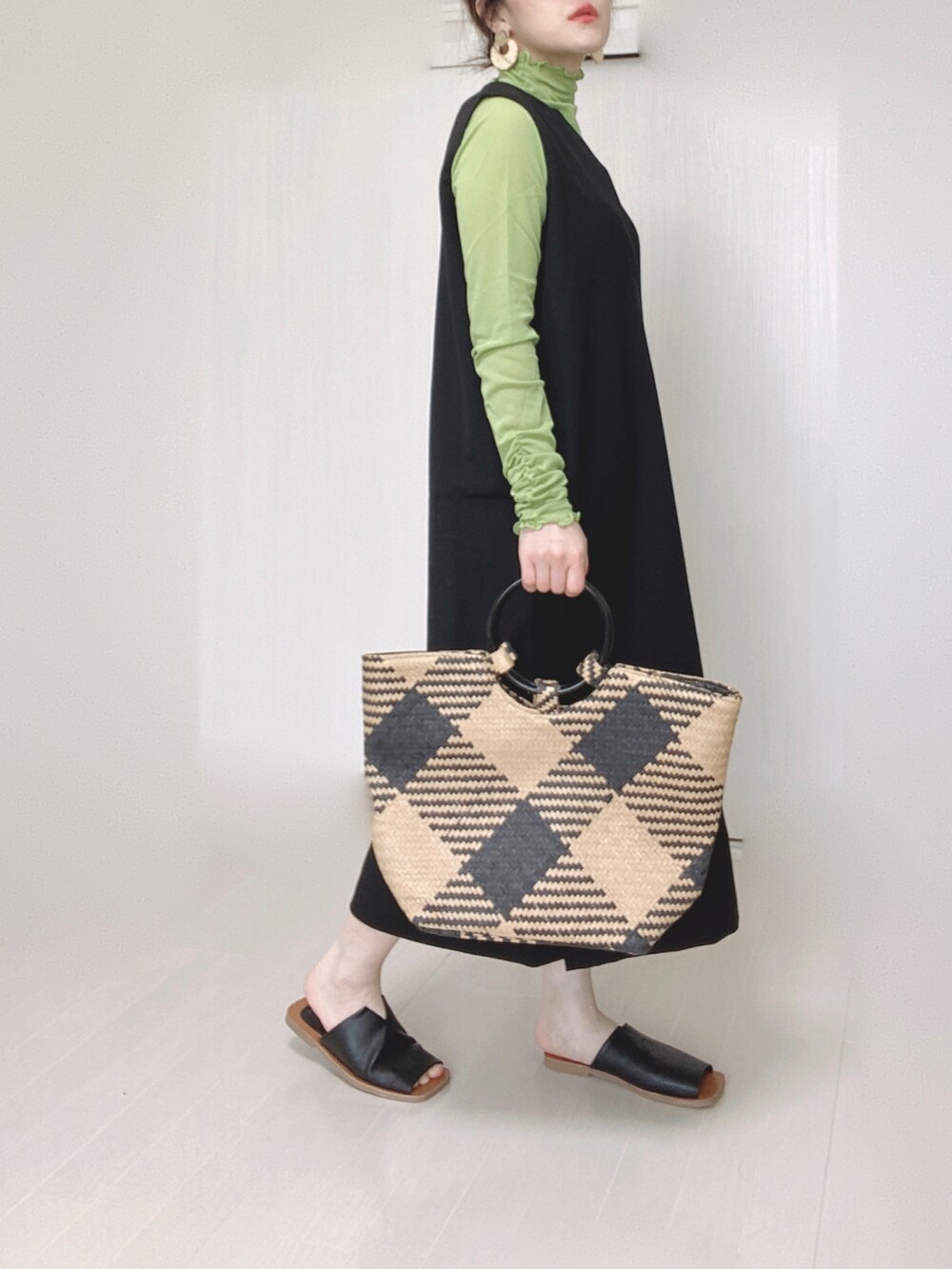 ブラック系のワンピース、ブラック系のトートバッグ、ブラック系のサンダルを着用したレディースの春コーディネートの3枚目の写真