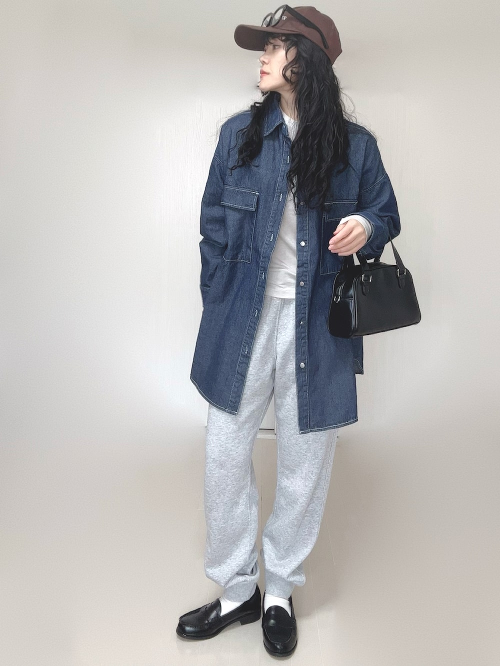 ブルー系のシャツ/ブラウス、ブラック系のボストンバッグ、ブラック系のローファーを着用したレディースの春コーディネートの3枚目の写真