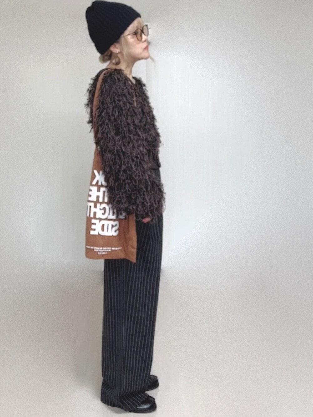 ブラック系のカーディガン/ボレロ、ブラック系のスラックス、ブラック系のローファーを着用したレディースの秋コーディネートの3枚目の写真