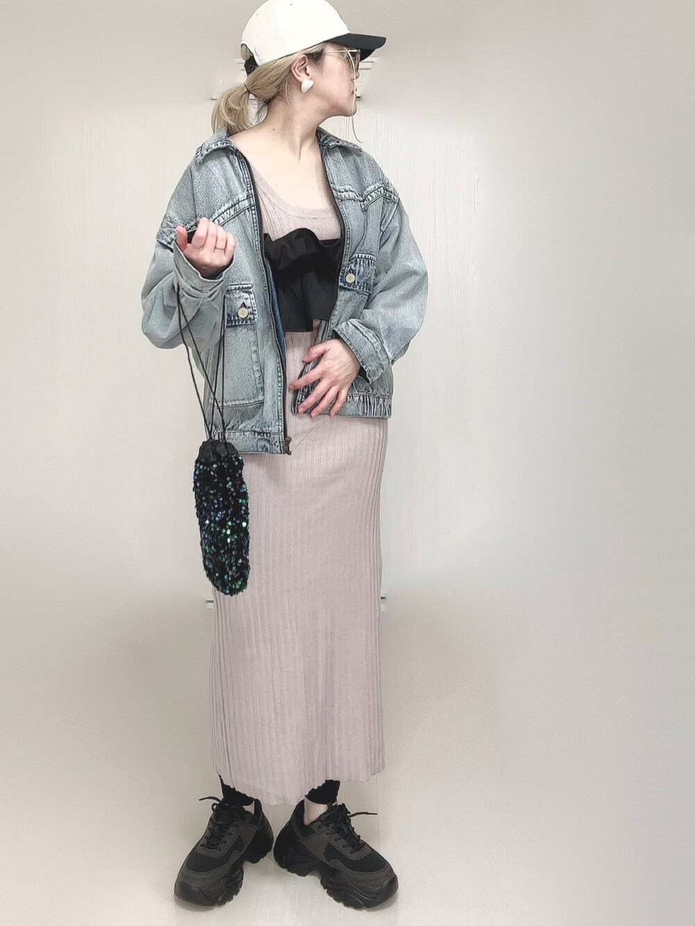 ブルー系のブルゾン、ブラック系のスニーカー、ブラック系のキャップを着用したレディースの春コーディネートの2枚目の写真