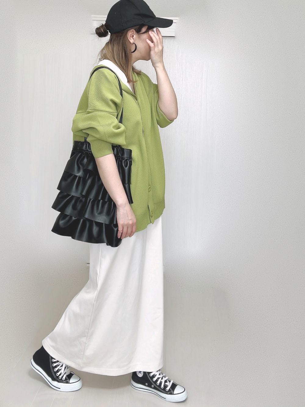グリーン系のカーディガン/ボレロ、ホワイト系のワンピース、ブラック系のスニーカーを着用したレディースの秋コーディネートの3枚目の写真