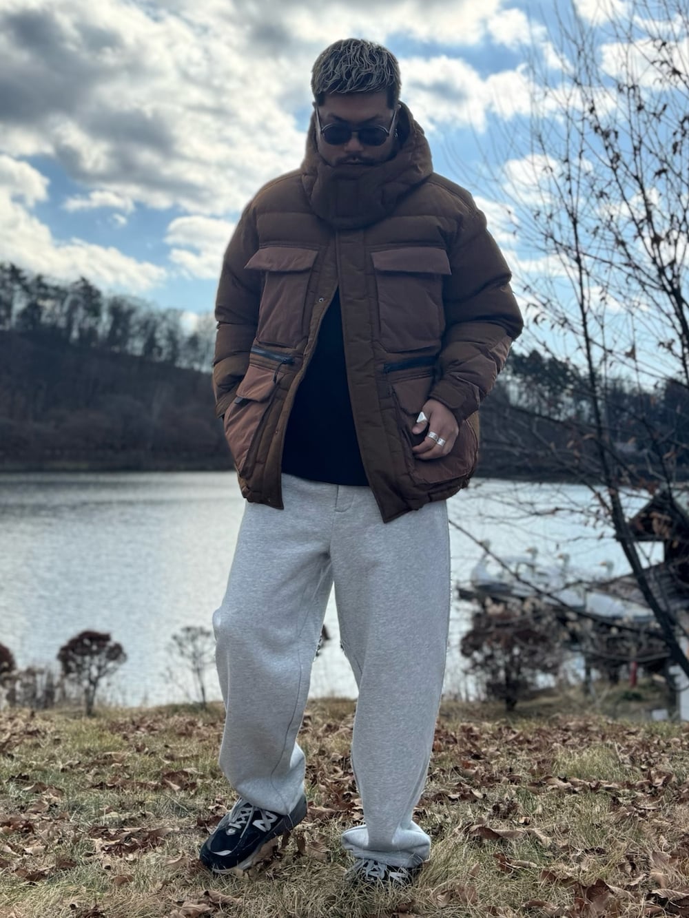 ブラウン系のその他アウター、グレー系のその他パンツ、ブラック系のメガネを着用したメンズの冬コーディネートの2枚目の写真