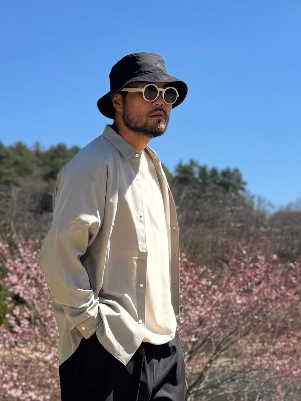 ホワイト系のTシャツ/カットソー、ブラック系のその他パンツ、ベージュ系のトップスを着用したメンズの春コーディネートの5枚目の写真