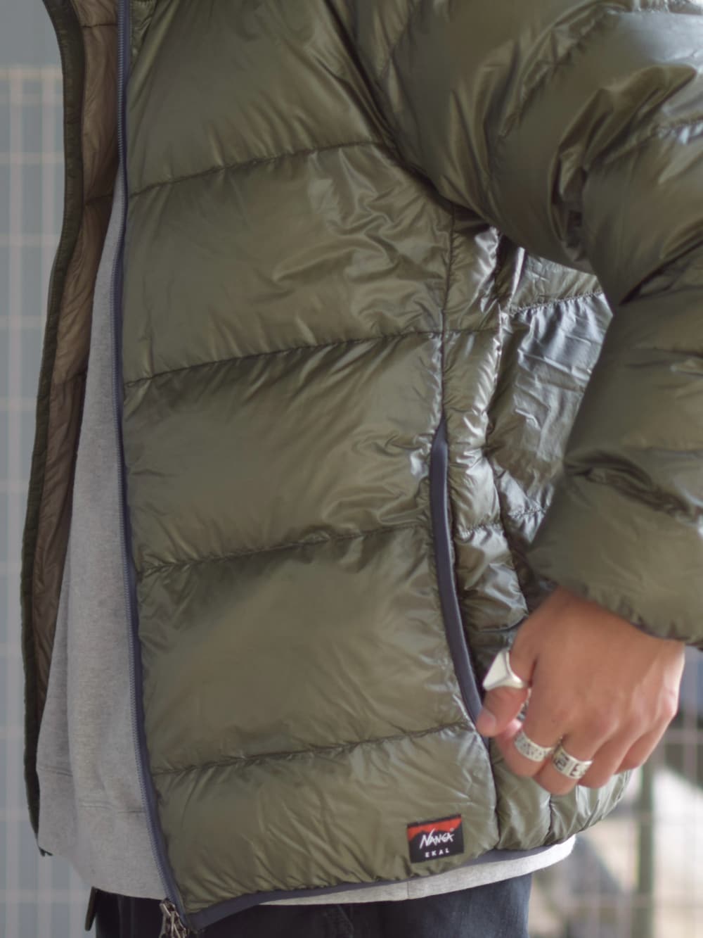 グリーン系のダウンジャケット/コート、グレー系のスウェット、ブラック系のチノパンツを着用したメンズの冬コーディネートの5枚目の写真