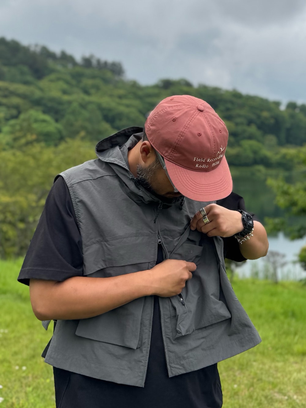 ブラック系のTシャツ/カットソー、グレー系のダウンベスト、ブラック系のメガネを着用したメンズの夏コーディネートの3枚目の写真
