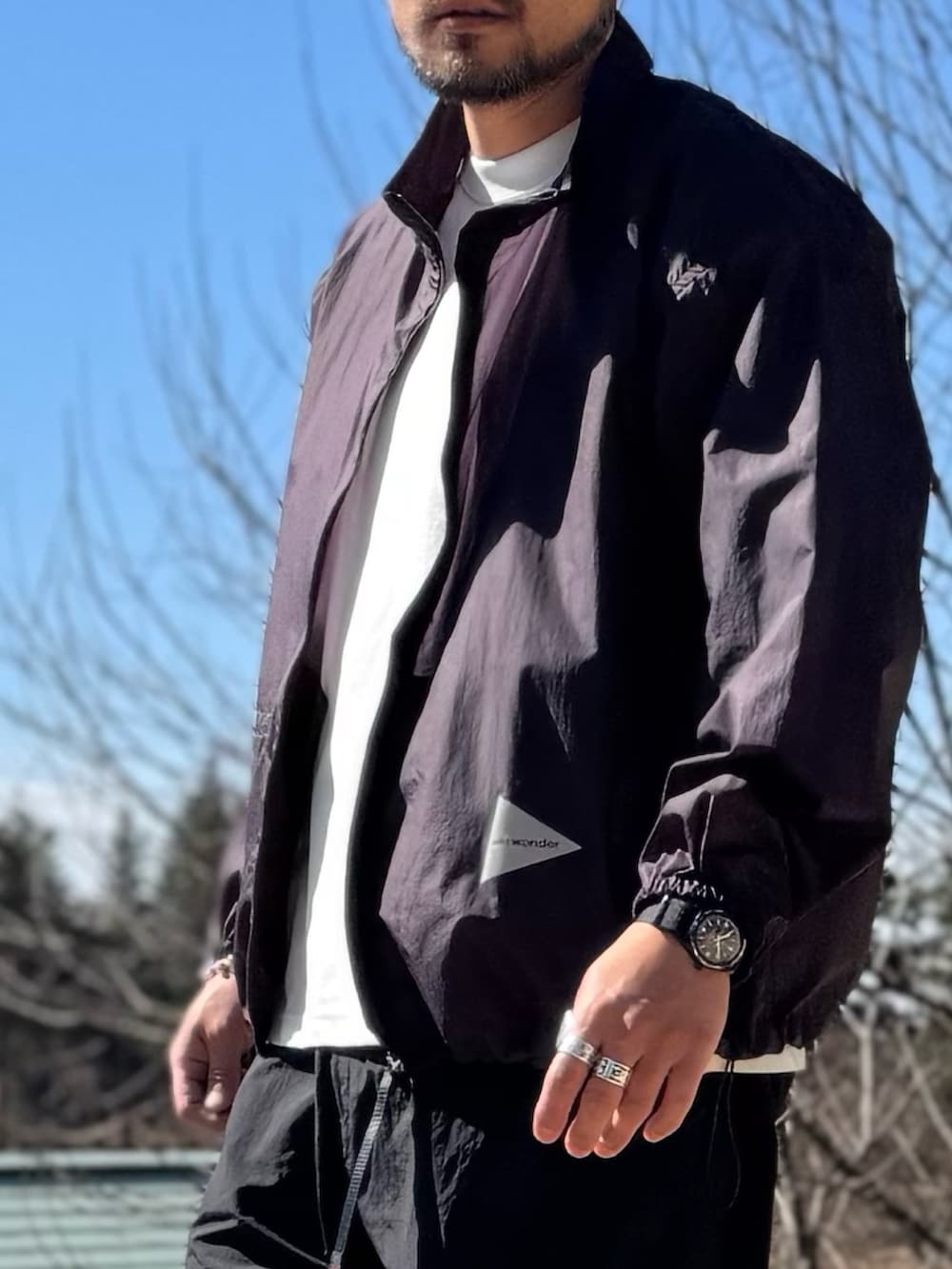 パープル系のテーラードジャケット、ブラック系のメガネを着用したメンズの春コーディネートの6枚目の写真