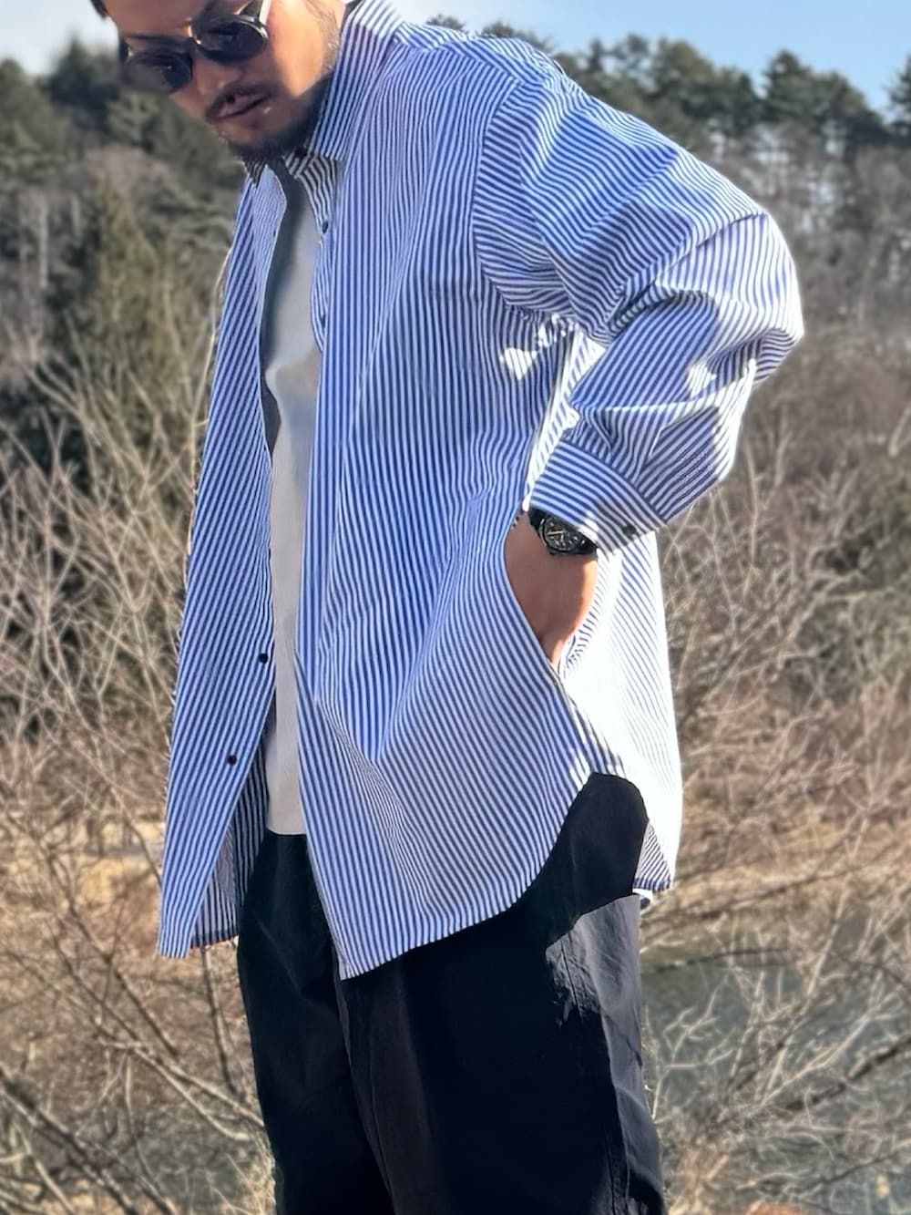 ブルー系のシャツ/ブラウス、ブルー系のその他パンツ、ブルー系のメガネを着用したメンズの冬コーディネートの4枚目の写真