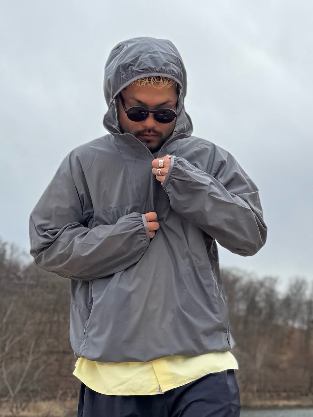 グレー系のナイロンジャケット、ブラック系のメガネを着用したメンズの春コーディネートの2枚目の写真