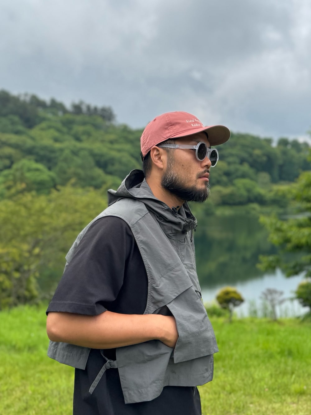 ブラック系のTシャツ/カットソー、グレー系のダウンベスト、ブラック系のメガネを着用したメンズの夏コーディネートの6枚目の写真