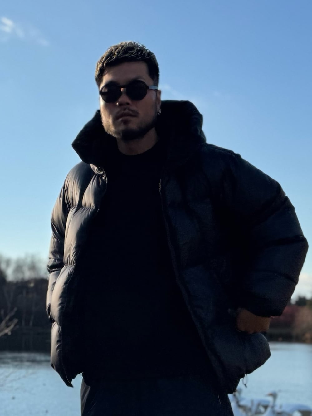 ブラック系のダウンジャケット/コート、ブラック系のメガネを着用したメンズの冬コーディネートの3枚目の写真